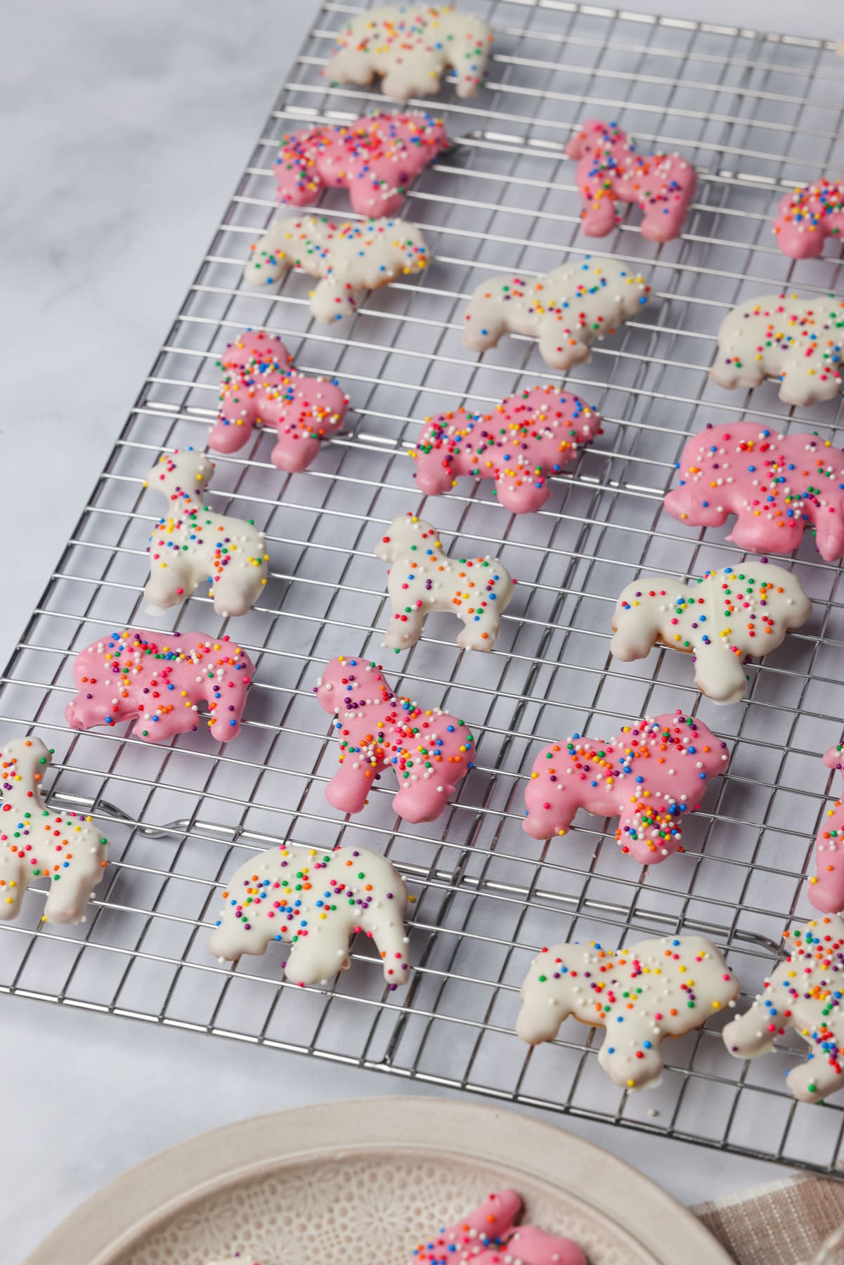 pink and white animal cookies on a wire rack